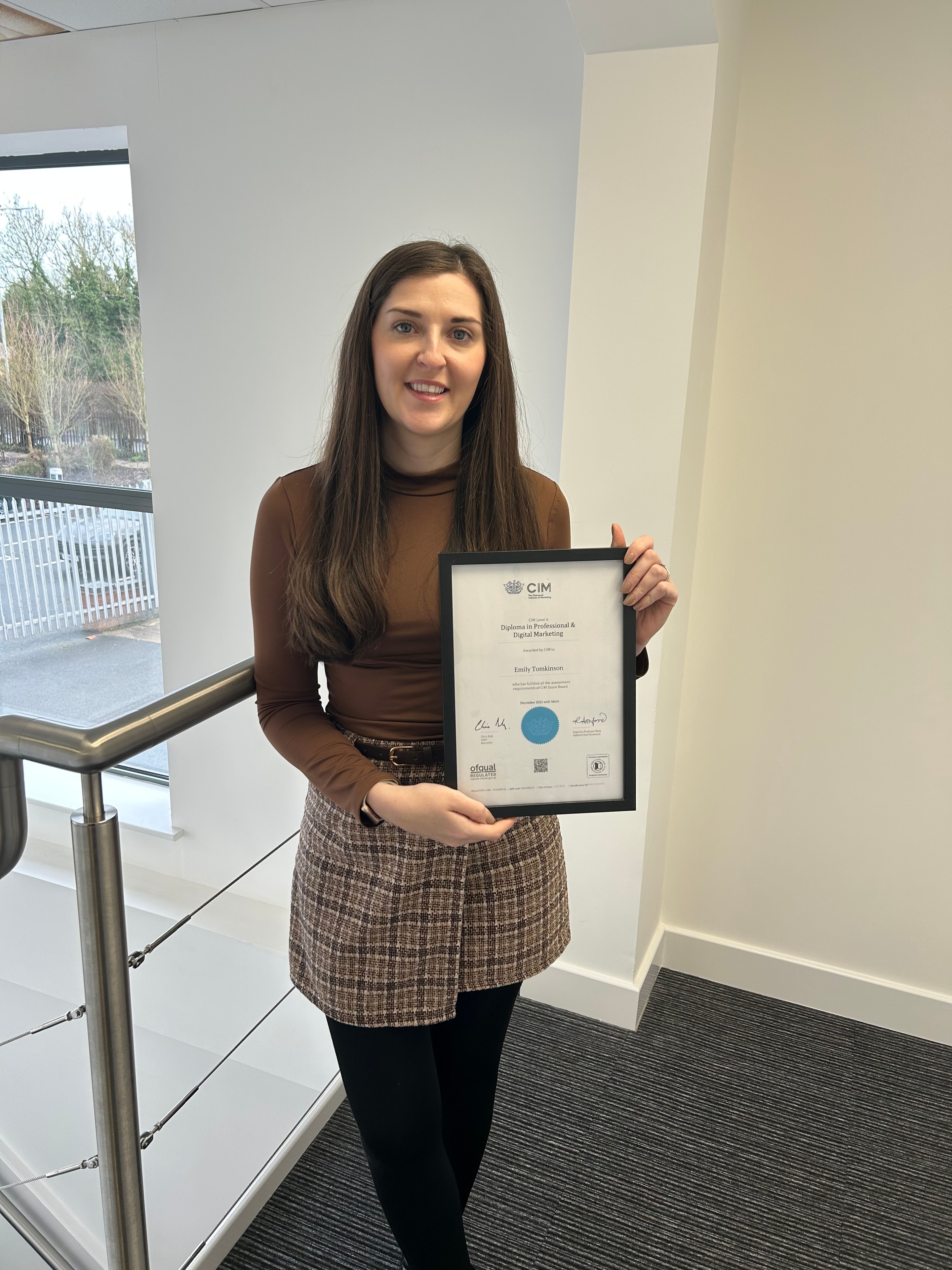 Emily holding her CIM Diploma in Professional & Digital Marketing certificate